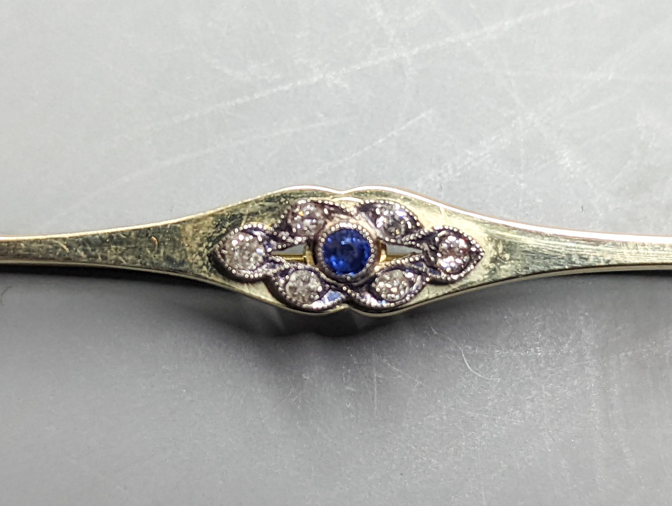 A pair of yellow metal and solitaire illusion set rose cut diamond earrings, 10mm and a 15ct, sapphire and diamond cluster set bar brooch, 66mm, gross weight 9.5 grams.